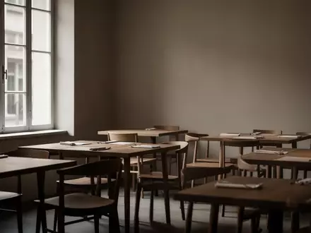Ein leerer, minimalistisch gestalteter Gastraum eines Restaurants mit Holztischen und Stühlen in natürlichem Licht. - Foto: über boerse-global.de