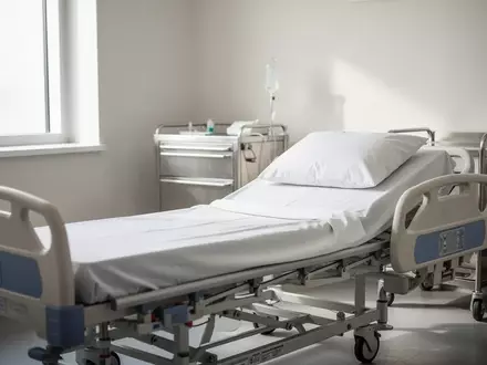Ein steriles, helles Behandlungszimmer in einer Klinik mit einem leeren Krankenhausbett und medizinischem Mobiliar. - Foto: über boerse-global.de