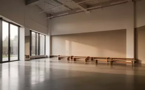Ein heller, minimalistischer Fitnessraum mit poliertem Betonboden und großen Fenstern, der Ruhe und Ordnung ausstrahlt. - Foto: über boerse-global.de