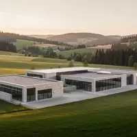 Eine weitläufige, ruhige Industrielandschaft in Oberfranken mit moderner Architektur eingebettet in eine grüne Hügellandschaft. - Foto: über boerse-global.de