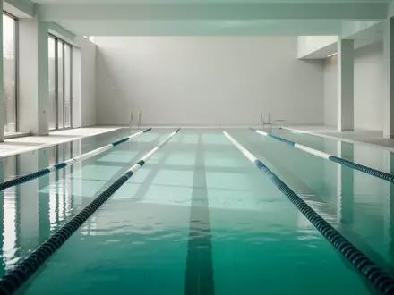 Ein ruhiges Schwimmbecken mit klarem, türkisfarbenem Wasser in einer hellen, modernen Schwimmhalle. - Foto: über boerse-global.de