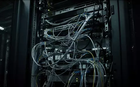 Dunkles, industrielles Server-Rack mit komplexer Verkabelung und tiefen Schatten. - Foto: über boerse-global.de