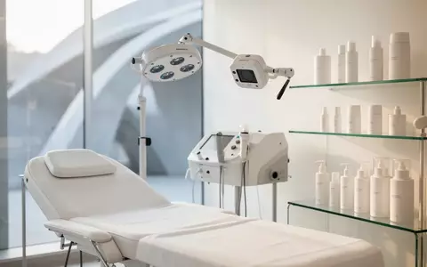 Ein minimalistischer, heller Behandlungsraum in einer dermatologischen Praxis mit einer medizinischen Behandlungsliege. - Foto: über boerse-global.de