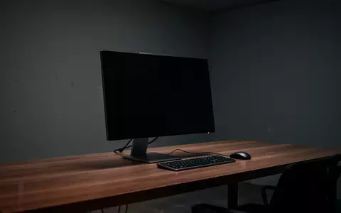 Ein minimalistischer Arbeitsplatz mit einem ausgeschalteten Monitor in einem abgedunkelten Raum. - Foto: über boerse-global.de