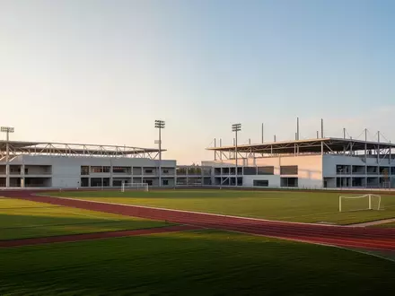 Modernes Sportforum-Gelände mit weitläufigen Außenanlagen und architektonischen Sportbauten bei Tageslicht. - Foto: über boerse-global.de