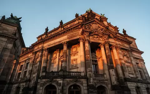 Die historische Fassade der Stuttgarter Staatsoper im goldenen Licht mit detaillierten Säulen und Steinverzierungen. - Foto: über boerse-global.de