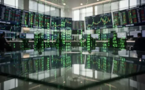 Abstrakte Darstellung von Börsenkursen mit grünen Lichtreflexen auf einem Schreibtisch. - Foto: über boerse-global.de