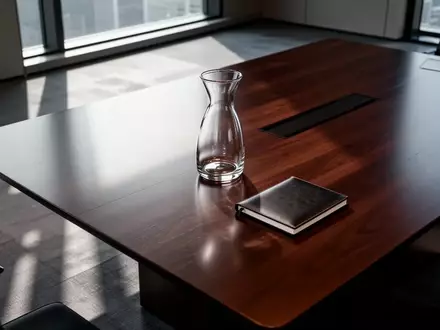 Ein leerer, minimalistischer Konferenztisch in einem modernen Büro mit natürlichem Lichteinfall. - Foto: über boerse-global.de