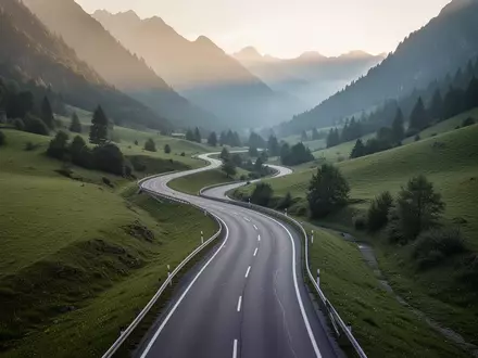 Eine leere, sich durch ein grünes Tal schlängelnde Landstraße im sanften Morgenlicht. - Foto: über boerse-global.de
