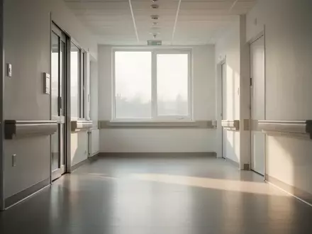 Ein leerer, sonnendurchfluteter Flur in einer modernen Pflegeeinrichtung mit minimalistischer Architektur. - Foto: über boerse-global.de
