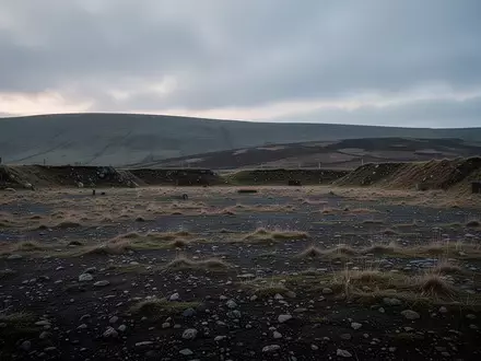 Eine weite, unebene Trainingsfläche in Wales bei Dämmerung, umgeben von sanften Hügeln unter einem bewölkten Himmel. - Foto: über boerse-global.de