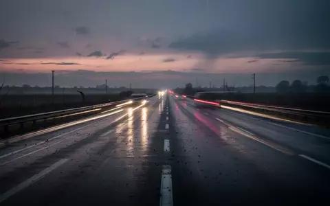 Eine menschenleere, regennasse Autobahn bei Dämmerung mit den Lichtspuren vorbeifahrender Autos. - Foto: über boerse-global.de