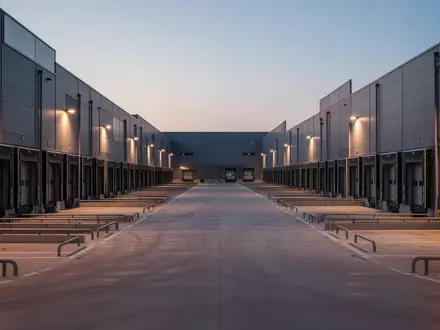 Ein modernes Logistikzentrum mit leeren Laderampen und Betonflächen in der Dämmerung. - Foto: über boerse-global.de