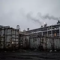 Industrielles Betriebsgelände mit großen Metallcontainern und Rohrleitungssystemen unter einem grauen Himmel. - Foto: über boerse-global.de