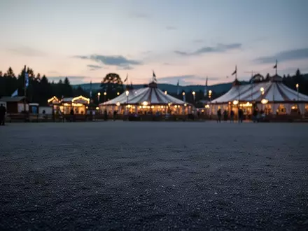 Weitläufiges, leeres Festgelände der Theresienwiese in der Abenddämmerung mit den Silhouetten der Festzelte im Hintergrund. - Foto: über boerse-global.de