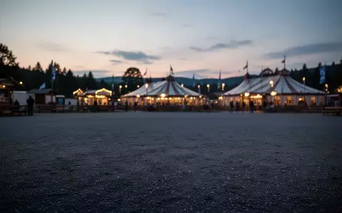 Weitläufiges, leeres Festgelände der Theresienwiese in der Abenddämmerung mit den Silhouetten der Festzelte im Hintergrund. - Foto: über boerse-global.de