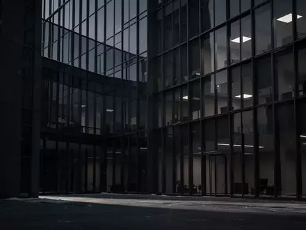 Dunkles, modernes Bürogebäude in der Dämmerung mit scharfen architektonischen Linien und einer kühlen, leeren Atmosphäre. - Foto: über boerse-global.de