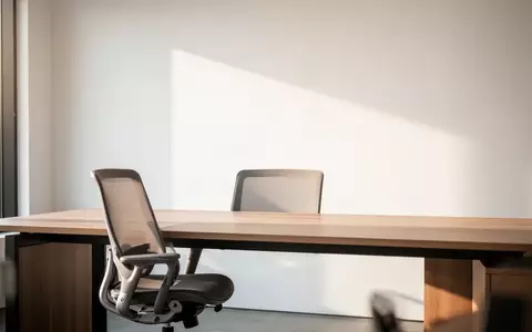 Ein minimalistisch gestalteter, heller Büroarbeitsplatz mit einem leeren Schreibtisch in einer ruhigen Arbeitsumgebung. - Foto: über boerse-global.de
