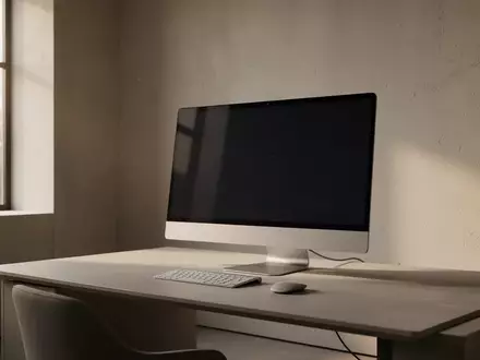 Ein minimalistischer, moderner Arbeitsplatz mit einem ausgeschalteten Monitor in einem hellen Raum. - Foto: über boerse-global.de