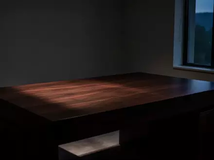 Ein minimalistisch eingerichteter, leerer Arbeitsbereich bei Dämmerung, der eine Atmosphäre der Stille und Verletzlichkeit ausstrahlt. - Foto: über boerse-global.de