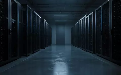 Dunkler, minimalistischer Serverraum mit metallischen Rack-Gehäusen in kühlem blauen Licht. - Foto: über boerse-global.de