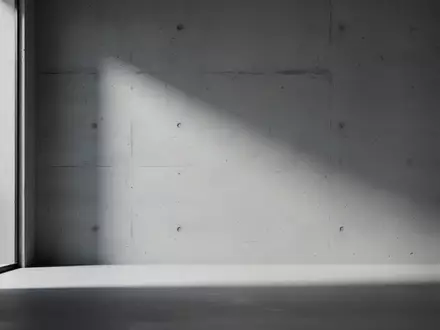Ein minimalistischer, leerer Raum mit sanftem, diffusem Licht und Schattenwurf an einer Betonwand, der eine technische Störung symbolisiert. - Foto: über boerse-global.de