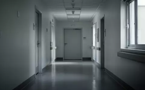 Ein leerer, steriler Krankenhausflur mit glattem Boden und geschlossener Tür in einem Pflegegebäude. - Foto: über boerse-global.de