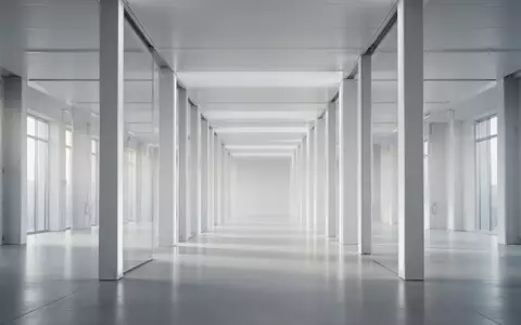 Eine minimalistische Architektur mit parallelen, hellen Säulen in einer leeren Halle als Symbol für strukturierte Prozesse. - Foto: über boerse-global.de
