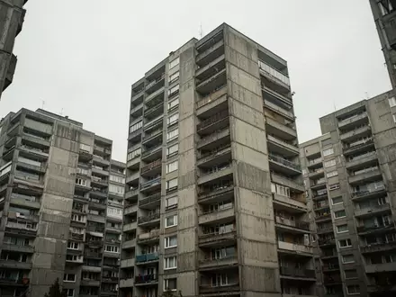 Ein brutalistischer Hochhauskomplex aus den 1970er Jahren mit sichtbaren Betonfassaden und Balkonen unter einem bewölkten Himmel. - Foto: über boerse-global.de