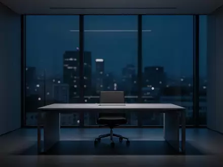 Ein minimalistisches, dunkel beleuchtetes Büro bei Nacht mit einem leeren Schreibtisch und Blick auf eine verschwommene Stadt. - Foto: über boerse-global.de