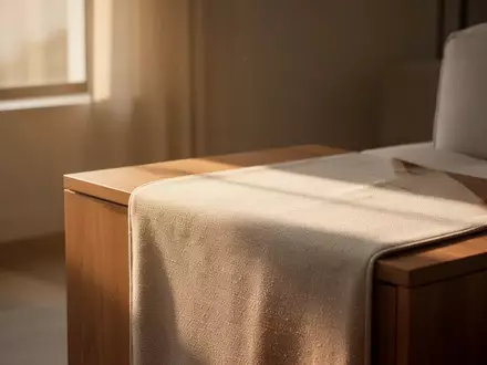 Ein minimalistischer, lichtdurchfluteter Wohnraum mit einer hölzernen Ablagefläche in ruhiger, natürlicher Atmosphäre. - Foto: über boerse-global.de