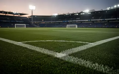 Ein leerer Fußballplatz bei Dämmerung mit grüner Rasenfläche und weißen Linien. - Foto: über boerse-global.de