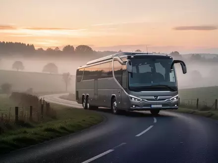 Ein Reisebus auf einer leeren Landstraße in einer nebligen Landschaft. - Foto: über boerse-global.de