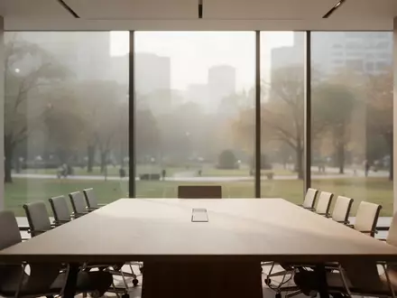 Ein minimalistischer, leerer Konferenzraum mit natürlichem Licht, der auf einen verschwommenen Stadtpark blickt. - Foto: über boerse-global.de