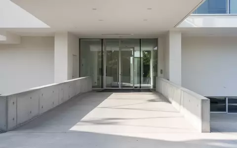 Eine moderne, helle Gebäudeeingangssituation mit einer barrierefreien, flachen Rampe bei Tageslicht. - Foto: über boerse-global.de