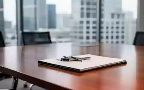 Ein minimalistischer Konferenztisch mit einem Notizbuch und einem Füllfederhalter vor einem modernen Bürofenster. - Foto: über boerse-global.de