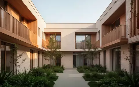 Moderner, heller Innenhof einer barrierefreien Wohnanlage mit begrünten Flächen und architektonisch klaren Fassaden. - Foto: über boerse-global.de