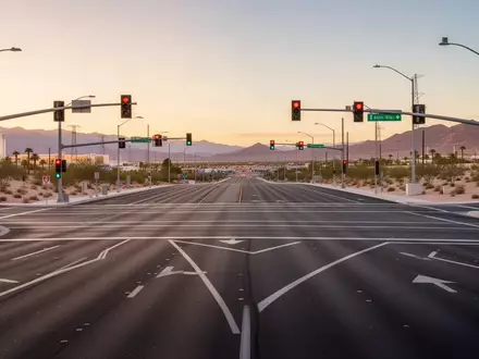 Eine moderne Straßenkreuzung in Las Vegas bei Sonnenuntergang mit klaren Fahrbahnmarkierungen und Ampeln ohne sichtbaren Verkehr. - Foto: über boerse-global.de