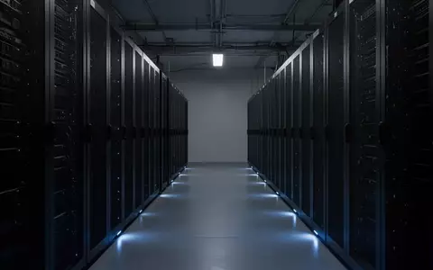Dunkler, minimalistischer Serverraum mit metallischen Rack-Gehäusen in einer industriellen Umgebung. - Foto: über boerse-global.de