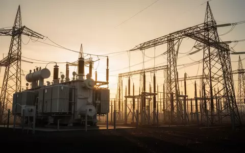 Hochspannungstransformatoren und Strommasten in einem Umspannwerk bei Sonnenaufgang - Foto: über boerse-global.de