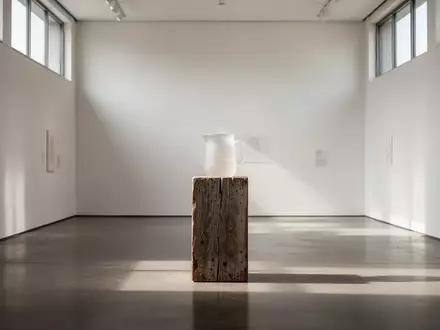 Ein minimalistisch gestalteter Ausstellungsraum mit einem einzelnen Exponat auf einem Sockel, das alltägliche Arbeit thematisiert. - Foto: über boerse-global.de