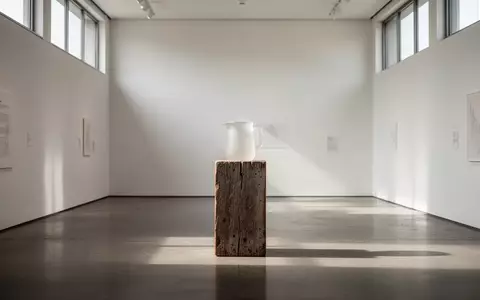 Ein minimalistisch gestalteter Ausstellungsraum mit einem einzelnen Exponat auf einem Sockel, das alltägliche Arbeit thematisiert. - Foto: über boerse-global.de