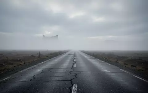 Eine leere, graue Landstraße unter einem bewölkten Himmel symbolisiert die politische Debatte um Kraftstoffpreise. - Foto: über boerse-global.de
