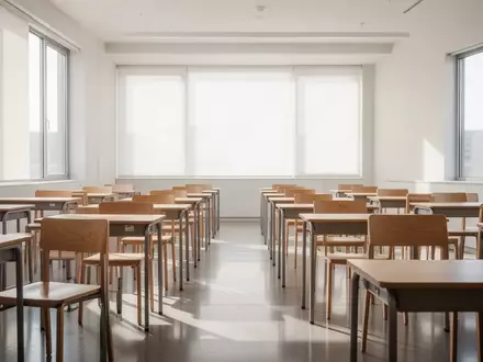 Ein heller, moderner Klassenraum mit leeren Schreibtischen und Stühlen bei natürlichem Tageslicht. - Foto: über boerse-global.de