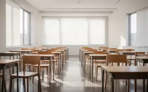 Ein heller, moderner Klassenraum mit leeren Schreibtischen und Stühlen bei natürlichem Tageslicht. - Foto: über boerse-global.de