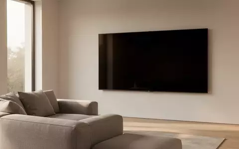 Ein minimalistisches, modernes Wohnzimmer mit einem ausgeschalteten Fernseher an der Wand und natürlichem Tageslicht. - Foto: über boerse-global.de