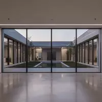 Ein minimalistisch gestalteter, leerer Büroraum mit großen Glasfronten und Blick in einen ruhigen Innenhof bei Dämmerung. - Foto: über boerse-global.de