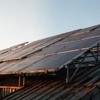 Eine weitläufige Photovoltaikanlage auf einem Industriedach unter einem klaren Morgenhimmel. - Foto: über boerse-global.de