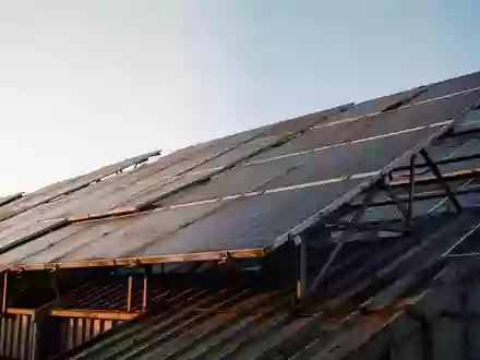 Eine weitläufige Photovoltaikanlage auf einem Industriedach unter einem klaren Morgenhimmel. - Foto: über boerse-global.de