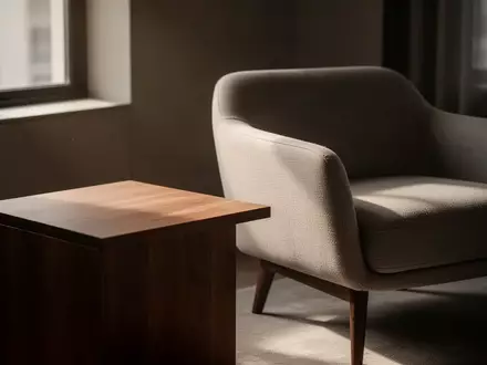 Ein minimalistisches, modern eingerichtetes Wohnzimmer mit einem leeren Beistelltisch und einem Sessel bei Tageslicht. - Foto: über boerse-global.de